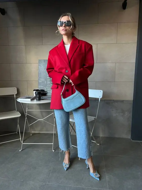 a refined outfit with a white top, blue jeans, blue slingbacks with embellished buckles and a red blazer plus a blue bag