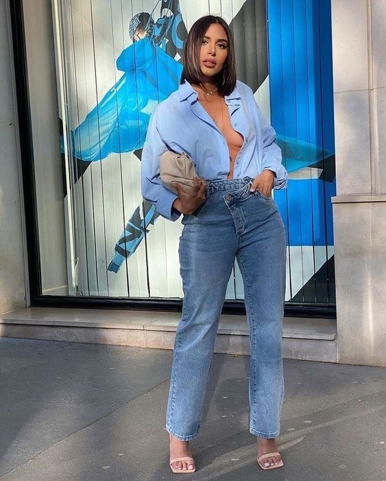 a sexy spring look with a blue short, blue asymmetrical jeans, tan sandals, a tan clutch and a necklace is wow