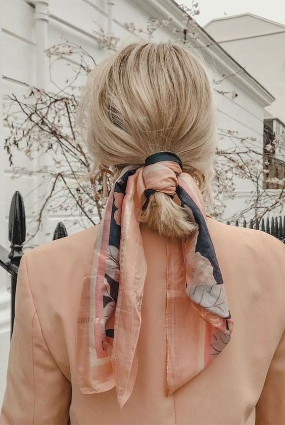 a simple and messy low ponytail with a messy top, a coral scarf as an accessory
