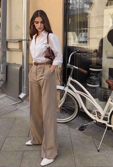 a simple every day look with a white button down, beige high-waisted pants, white mules and a brown baguette bag