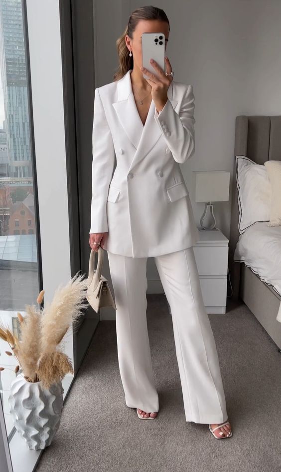 a sophisticated white power suit with a long blazer, white minimal shoes and a small neutral bag to look and feel confident
