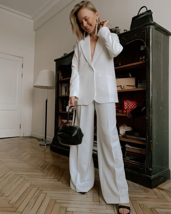 A spring bridal shower outfit with a white pantsuit, black heels and a small black bag are a cool combo for any bride to be