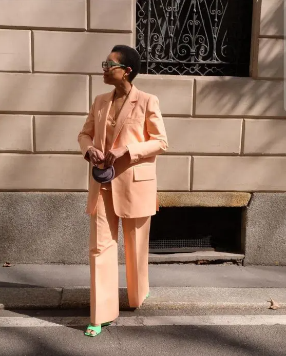 a stylish Peach Fuzz look with a pantsuit, an oversized blazer, a top, green shoes and a necklace plus a tiny bag