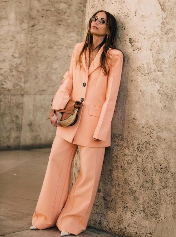 a trendy look with a Peach Fuzz pantsuit with an oversized blazer, wideleg pants, neutral shoes and a bag for spring or summer