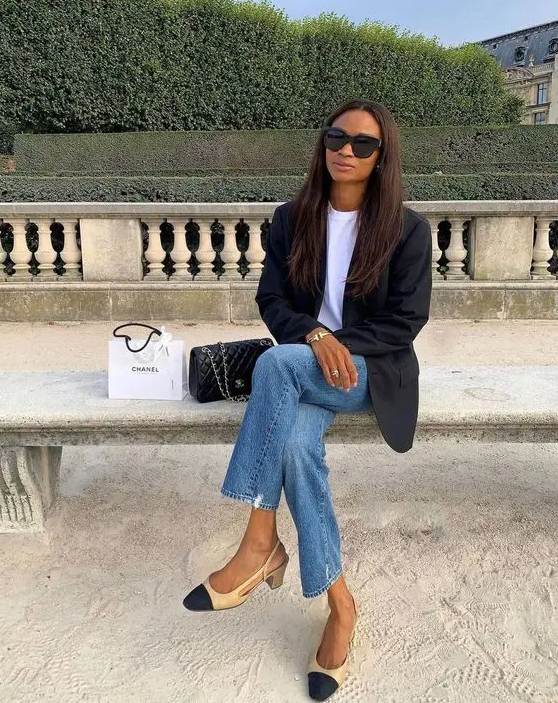 A white t shirt, blue jeans, a black oversized blazer, two tone shoes and a black bag are a chic look for spring