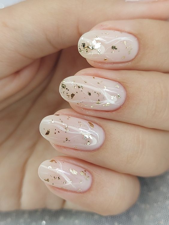 Almond shaped milky nails with gold foil are a very chic and catchy idea for a glam look or for a wedding