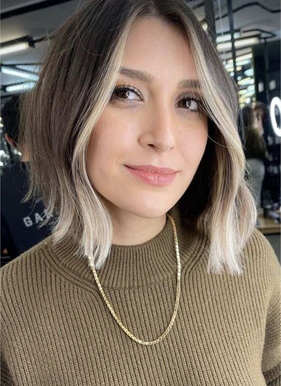 an asymmetrical brunette bob with blonde contouring and some waves is a cool idea to try right now