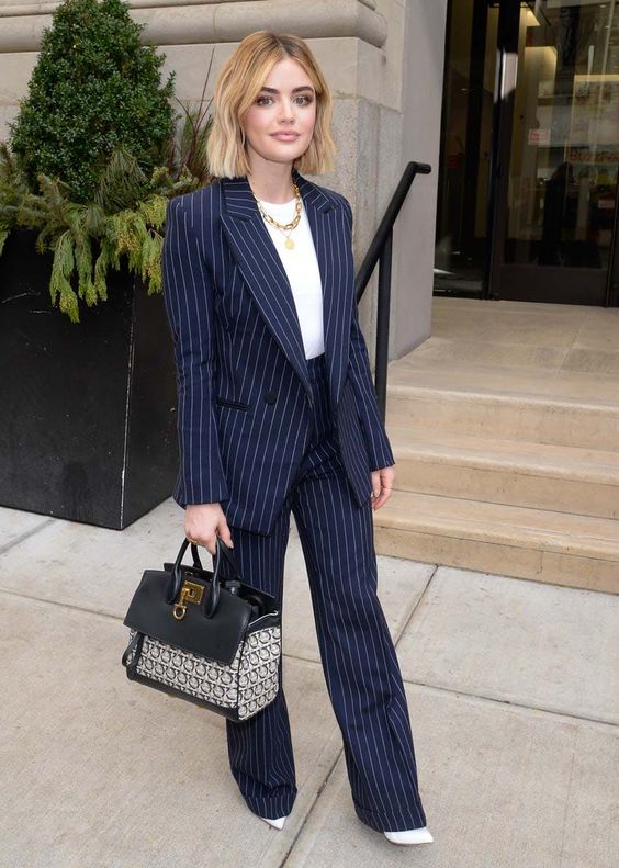 an elegant navy thin stripe pantsuit, a white top, white shoes, a chain necklace and a bag for a bold look in the fall or winter