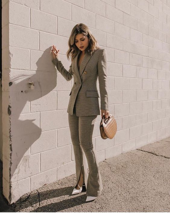 an eye-catchy look with a grey power suit with slits on the flare pants, white shoes and a small brown bag