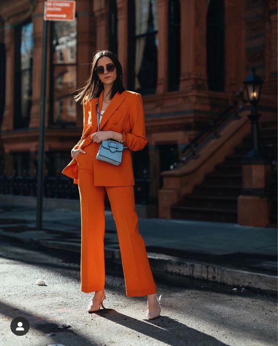 an orange power suit, a white top, nude shoes and a small blue bag are a great combo for a bold spring or summer look