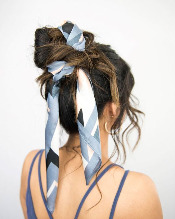 an updo with a volumetric top, waves down and a blue printed scarf interwoven into the hairstyle are a lovely combo