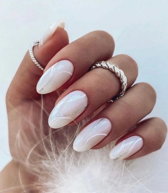 long almond milky nails with white and silver glitter art are amazing for those who want something fresh but not too much in your face