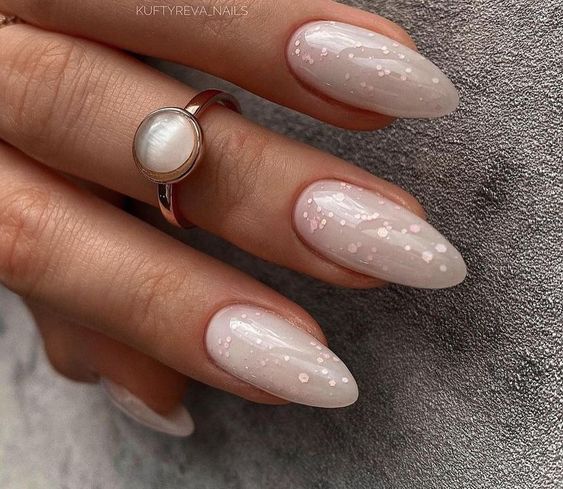 Long almond shaped milky nails with blush flitter are adorable and very chic and delicate, perfect for a girlish look