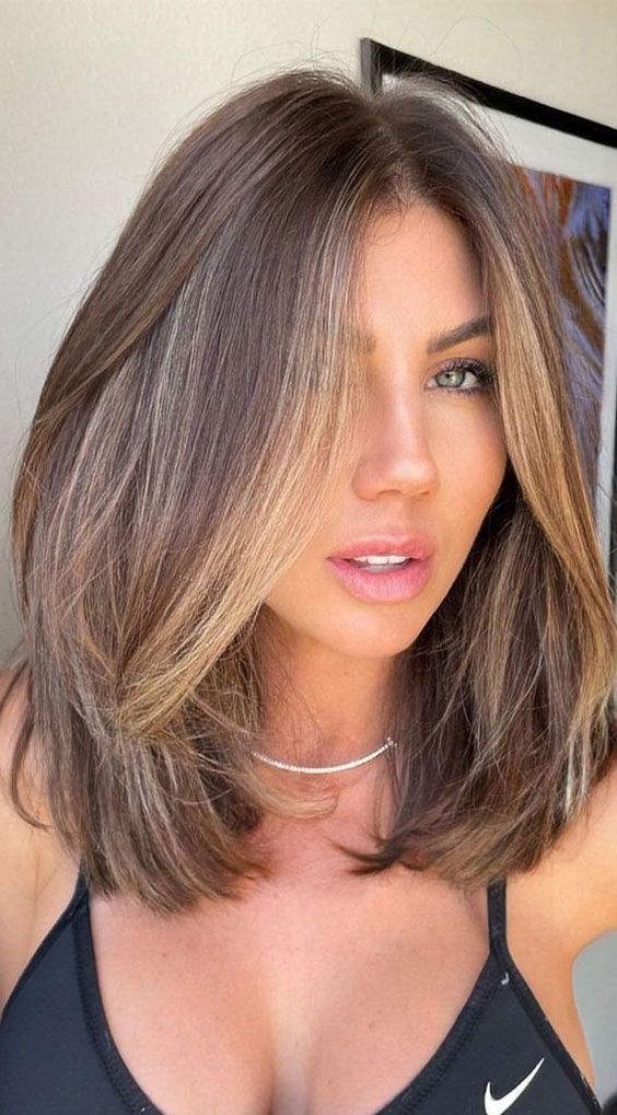 medium-length brunette hair with golden blonde contouring and a lot of volume is adorable