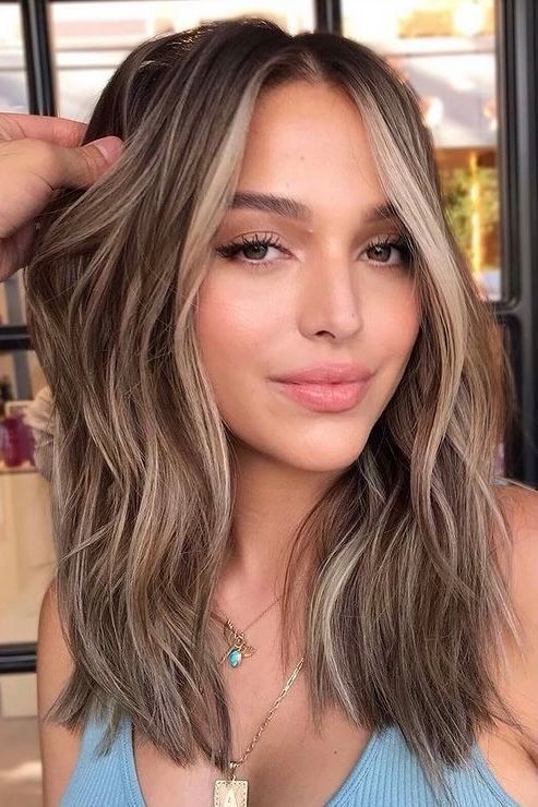 medium-length light brunette hair with blonde contouring and messy waves is a cool and chic idea
