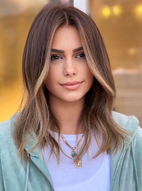 medium-length mousy brown hair with blonde contouring and waves is a cool and relaxed way to highlight the face