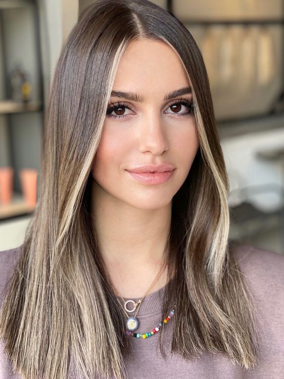 medium-length mousy brown hair with blonde contouring is a cool way to illuminate the face features