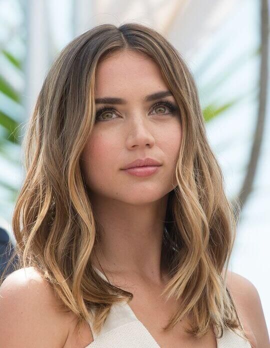 mousy brown hair with blonde contouring and lowlights, with messy waves for a cool and relaxed look