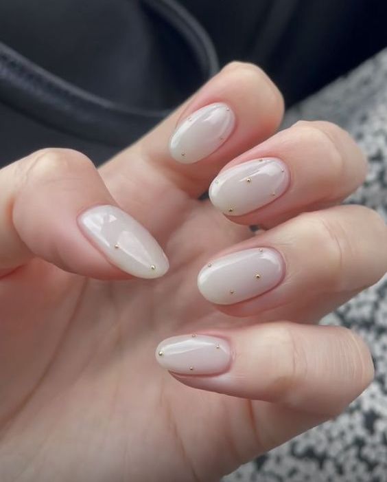 oval milky nails with tiny gold beads is a cute and lovely version of viral milky manicure, they look awesome