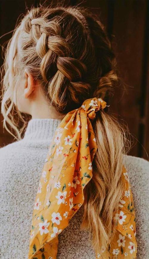Two braids into one low ponytail, with face framing hair and a bold orange floral scarf for an accent