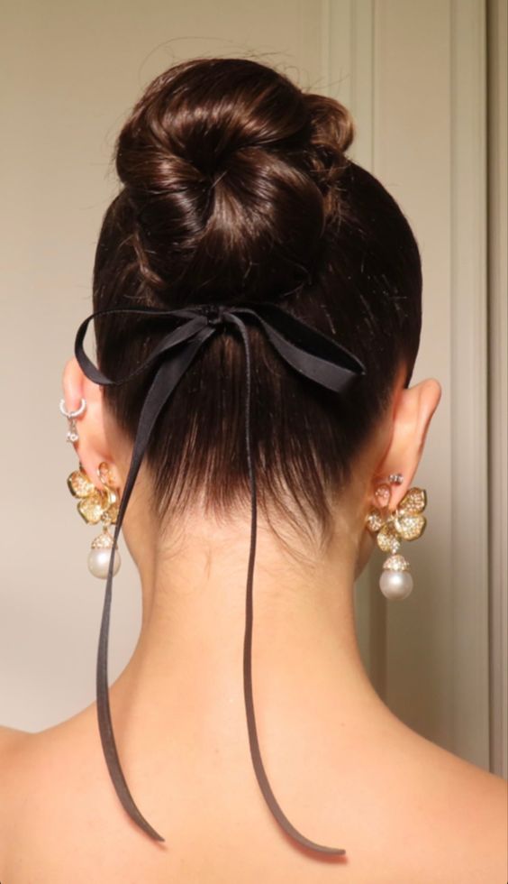a ballerina bun with a sleek top and a small black bow are a lovely combo, this bow adds elegance and chic