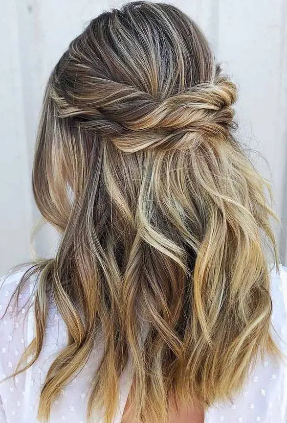 a beautiful and relaxed half updo with a bump on top, a double twisted halo and waves down is a cool idea