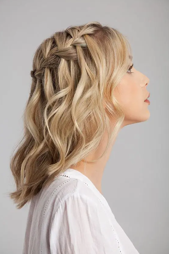 a blonde medium length half updo with a braided top and waves down is a stylish boho wedding idea