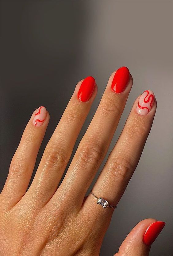 a bold red manicure with swirls is a trendy idea, a fresh alternative to classic reds