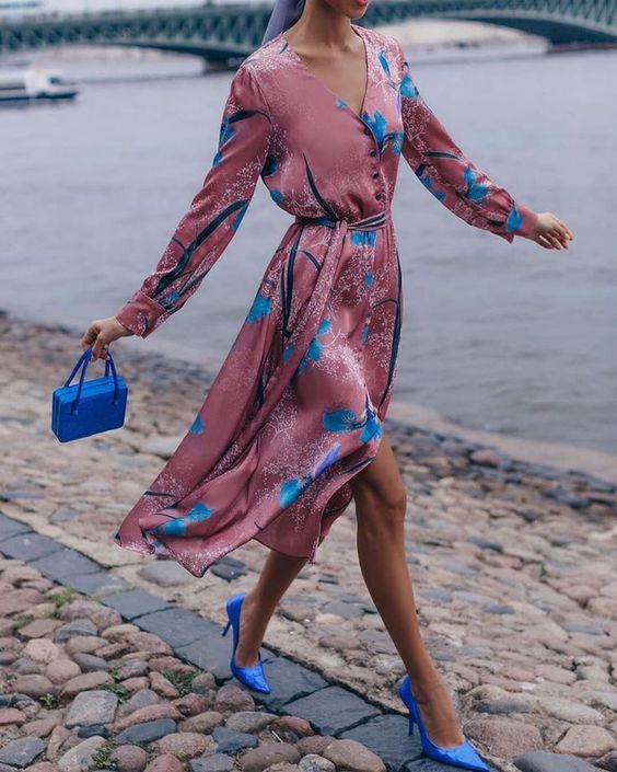 a bold spring wedding guest look with a pink midi dress with blue prints, a bold blue mini bag and matching shoes