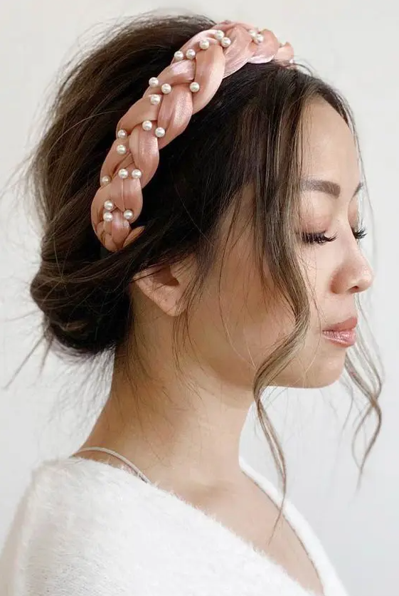 a casual wedding updo accented with a delicate braided pink headband with pearls is a stylish and chic solution