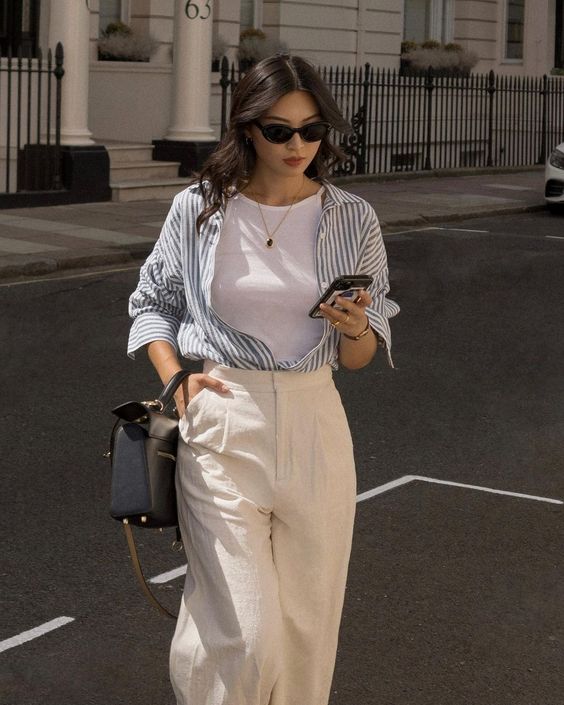 a classic spring look with a white tank top, a striped button down, white trousers and a black bag will never go out of style