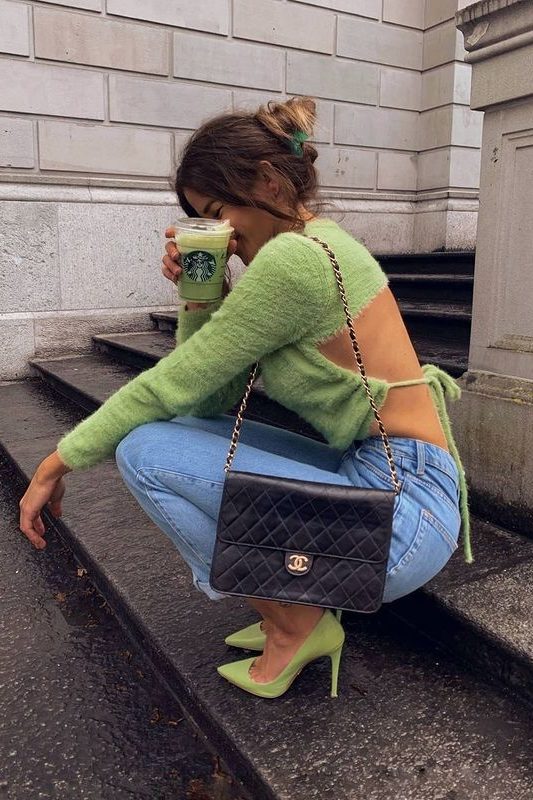 a classy Easter look with a green mohair jumper with a cutout back, blue jeans, green heels and a black bag