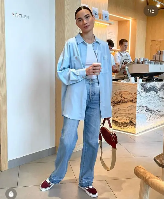 a classy and comfy spring look with a white top, blue jeans, a blue oversized shirt, burgundy sneakers and a burgundy saddle bag