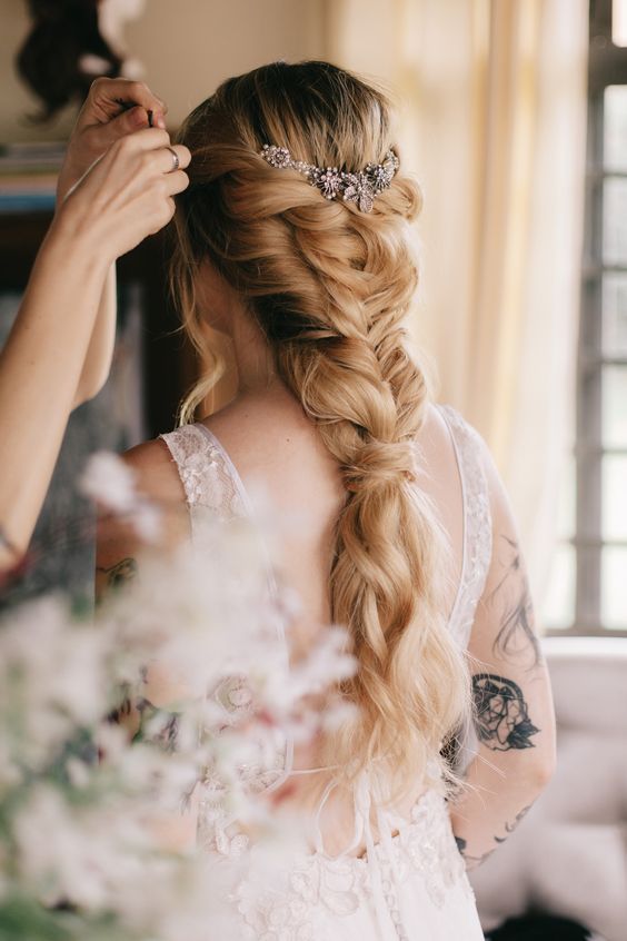 a classy loose braid into a ponytail with an embellished hair vine is a cool and chic idea for a weddin
