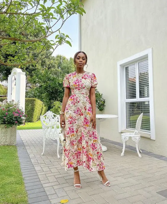 a colorful floral maxi dress with a high neckline, puff sleeves, white shoes and a small bag are a lovely combo for a bridal shower
