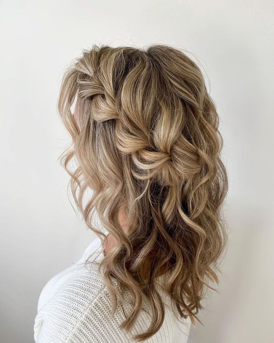 a cool and girlish half updo with a loose side braid, waves and a bump on top is amazing for a more relaxed wedding