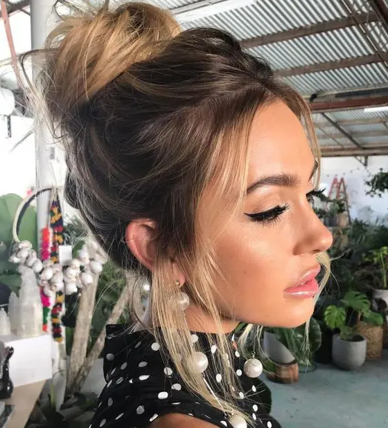 a cool messy wrapped top knot with a bump on top and face-framing hair is a chic and stylish idea