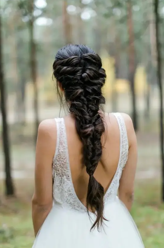 a creative twisted braided hairstyle on long and thick hair for a relaxed look at a wedding, it can be worn to less and more formal weddings