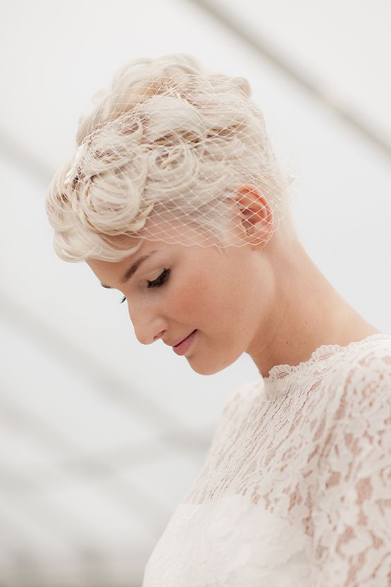 a curly platinum blonde pixie haircut with a small brdcage veil is a lovely idea for a wedding, it looks pretty and chic