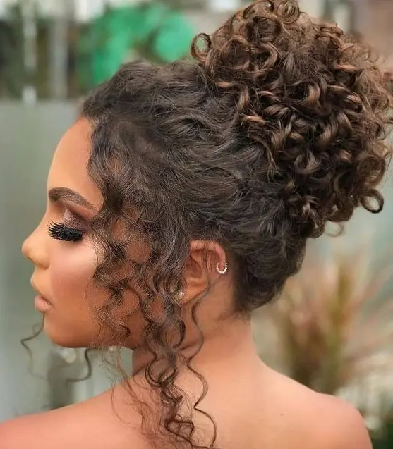 a curly top knot with some curls framing the face is a dreamy idea for a wedding