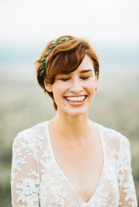 a ginger brown long pixie haircut with waves and a greenery touch is a chic and lovely idea for a wedding