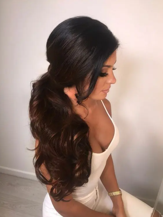 a gorgeous dimensional wavy side poyntail with a sleek volume on top is an amazing idea for a modern bride