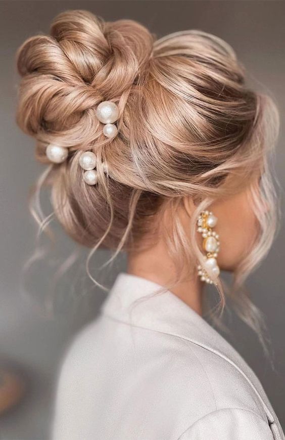a gorgeous glam wedding hairstyle with a loose twisted top knot and a volume on top, some locks down is amazing