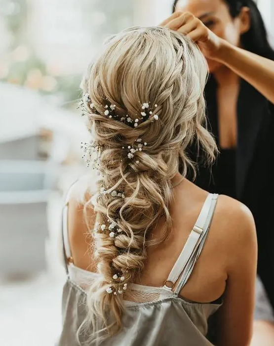 a gorgeous loose and messy twisted braid with a couple of braided halos and baby’s breath tucked into the braid