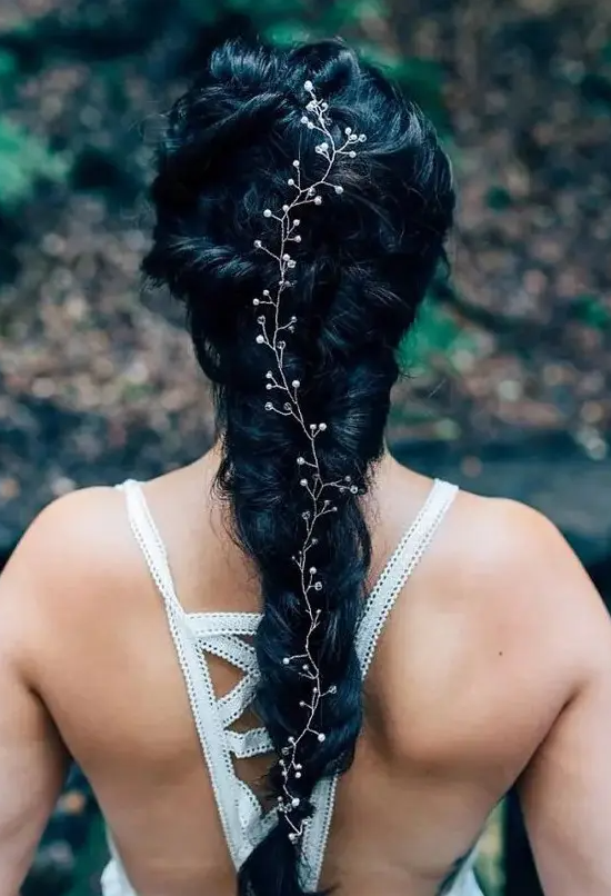 a gorgeous twisted black braid with a lovely hair vine to accent it is a great idea for a boho or woodland bride