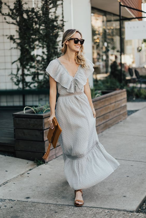 a grey polka dot maxi dress with ruffles, lace inserts, a brown clutch and brown strappy shoes