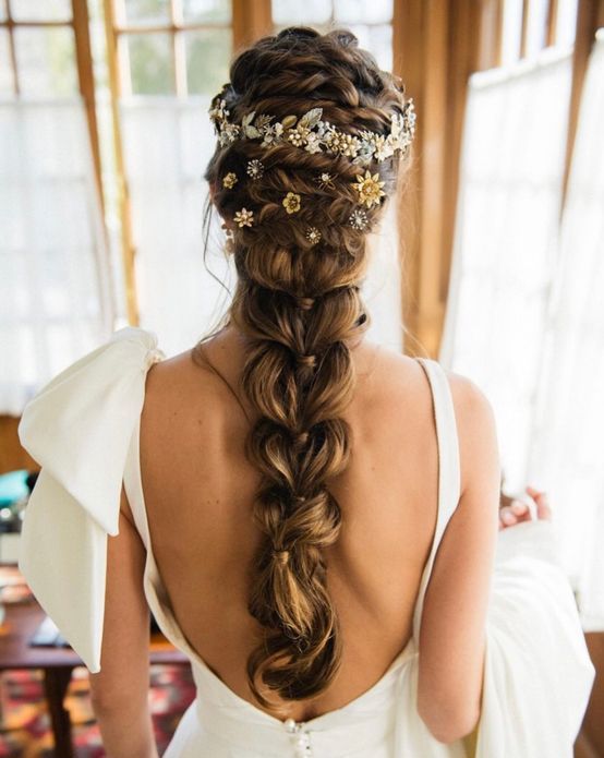 a large loose braid with a braided top and a floral hair vine and hair pins is a glam and cool idea to rock