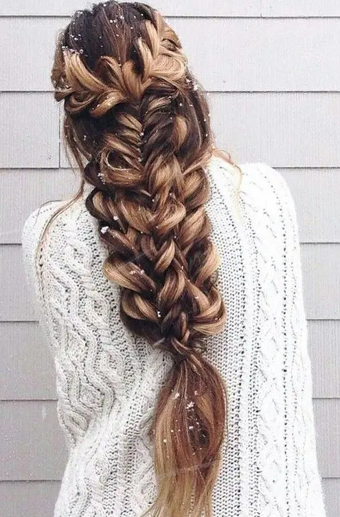 A large voluminous braid made of several braids on long hair looks just jaw dropping
