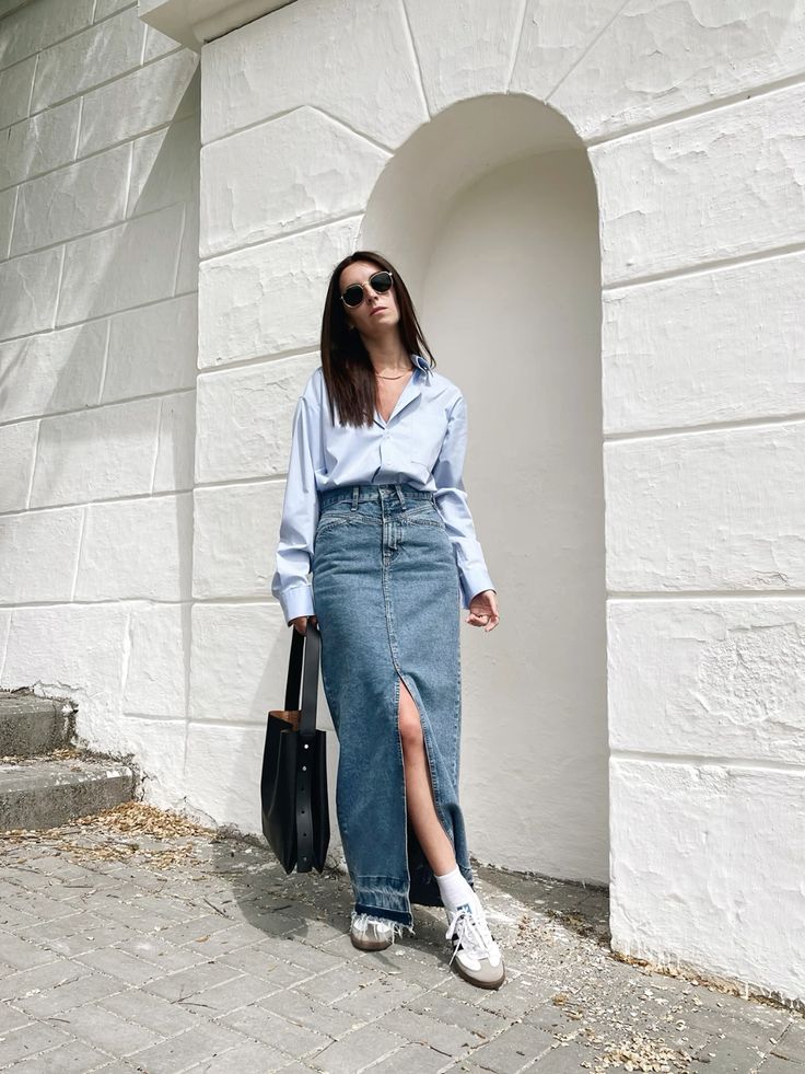 a light blue button down, a blue denim maxi skirt, white sneakers and a black bag for spring