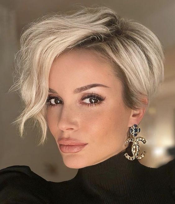 a long blonde pixie cut with a lot of volume and waves is a cool and catchy hairstyle to rock for a wedding